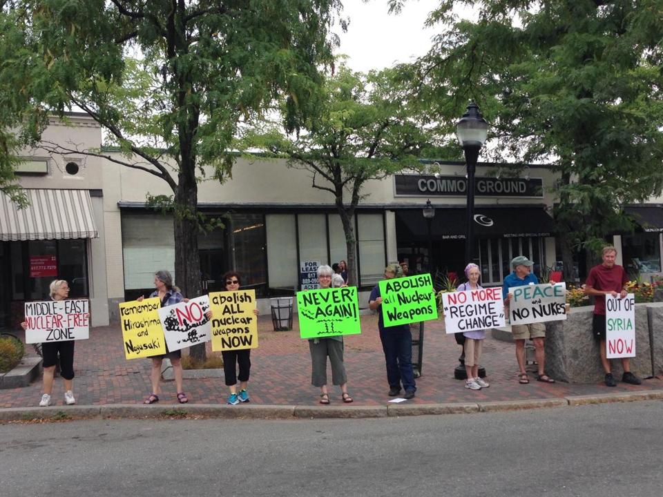 Members of the Arlington chapter of United for Justice with Peace hold signs in Arlington Center in protest of nuclear weapons on Massachusetts Avenue. Photo: Reenat Sinay
